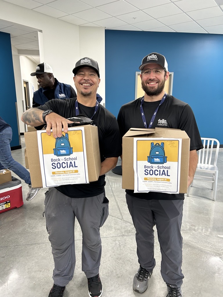 Fello Communities team members carrying school supply boxes for the families