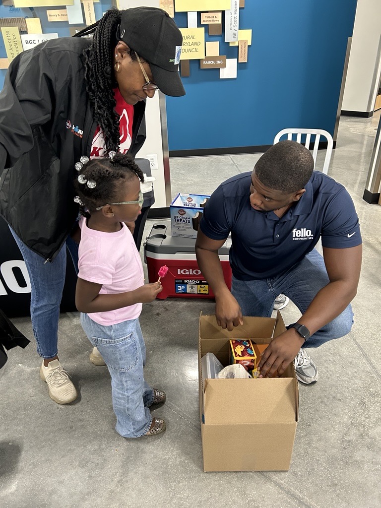 Keenan Troxler, Assistant Director of Property Operations handing out supplies to another family