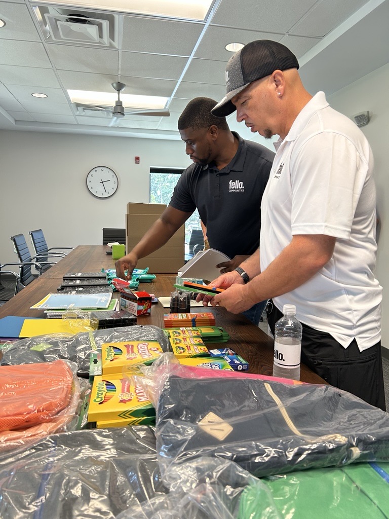 Two men packing boxes with school supplies