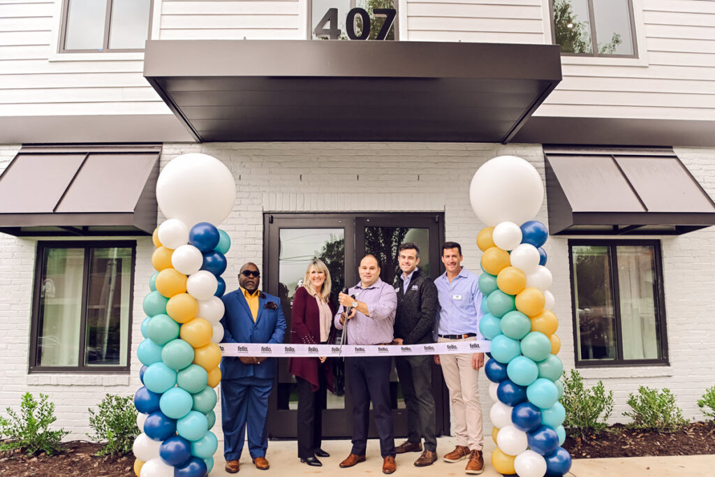 5 people preparing to cut the ribbon at 407 Brooklett's Ave. in Easton, Md for Fello's new leasing office