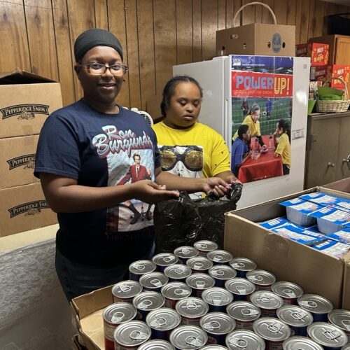 Two people filling bags with donated food