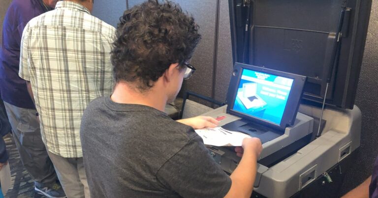 Person practicing submitting their vote using a voting machine