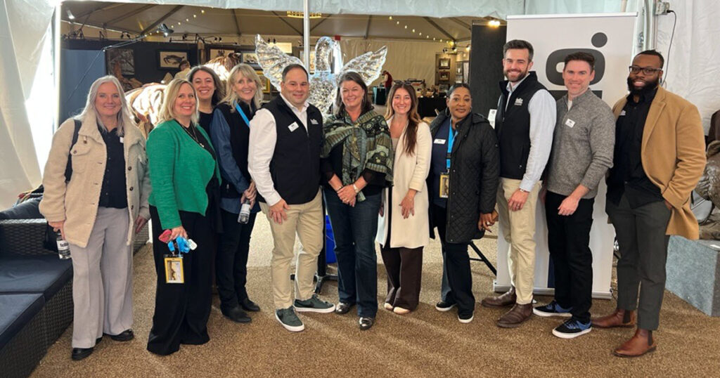 11 people lined up and smiling for a group photo at the 2025 Waterfowl Festival