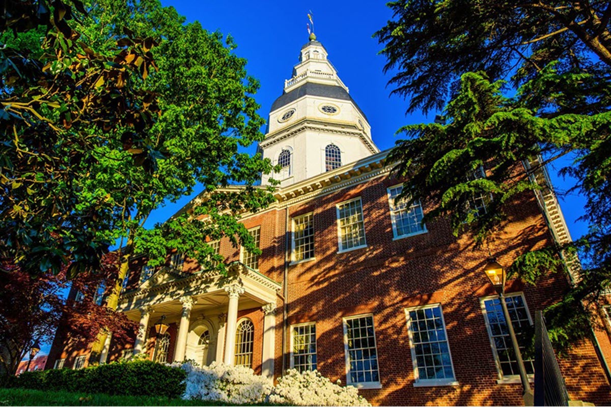 Exterior view of the Maryland State House surrounded by green trees during Maryland’s Legislative Session