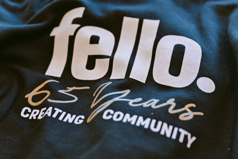 Black sweatshirt with a Fello logo in white and 65 years creating community