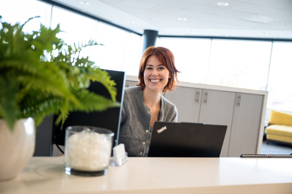 Woman smiling at a reception desk.
