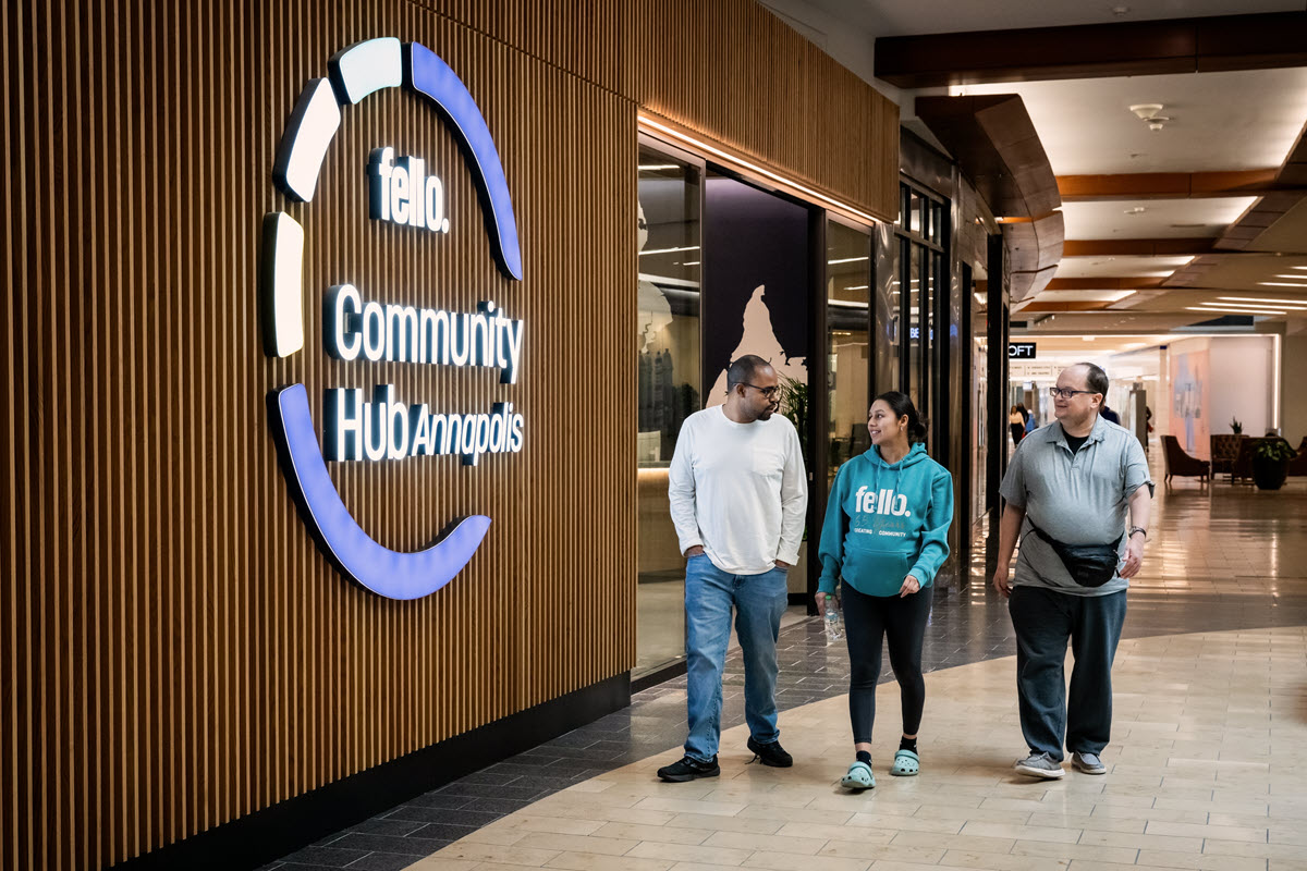 Three people walking in the Annapolis Mall in fron of Fello at The mall
