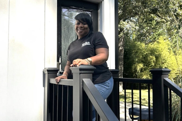Tyrice standing on a front porch wearing a black Fello shirt